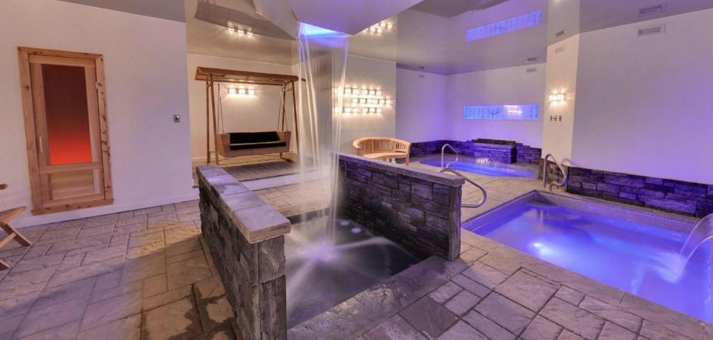 baño grande con piscina y bañera de hidromasaje en Hôtel-Auberge la Grande Maison et Spa en Baie-Saint-Paul