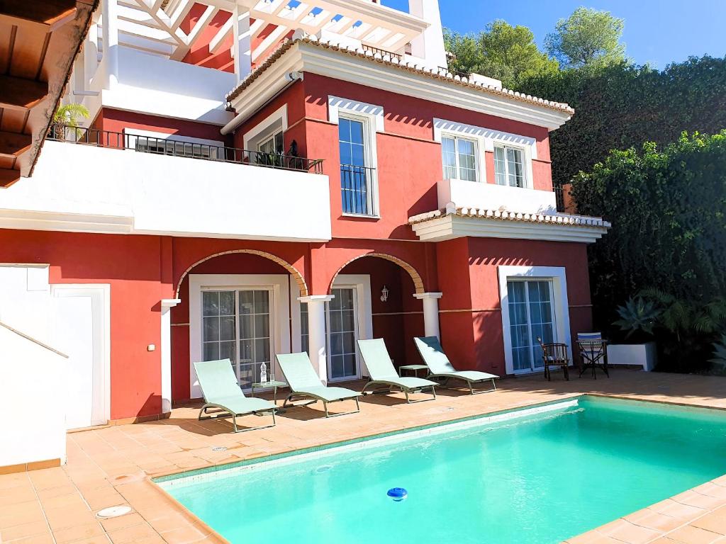 a house with a swimming pool in front of a house at Casa Roja in Almuñécar