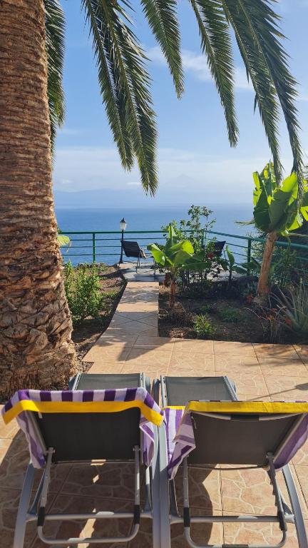 a couple of chairs sitting on a patio near the ocean at Los Cerrajones: spectacular views from the cliff in Agulo