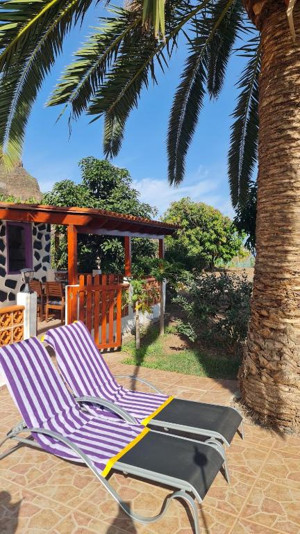 a couple of lounge chairs sitting on a patio at Los Cerrajones: spectacular views from the cliff in Agulo