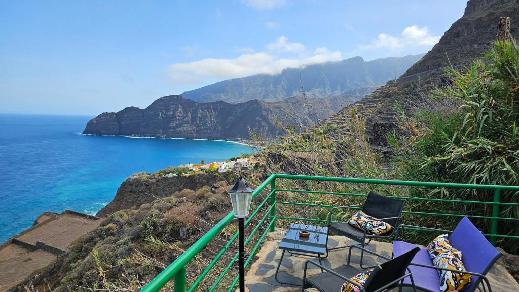 a balcony with chairs and a view of the ocean at Los Cerrajones: spectacular views from the cliff in Agulo