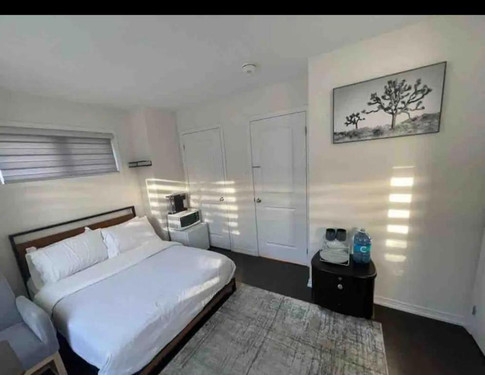 1 dormitorio con cama blanca y alfombra en Ensuite guest room with separate entrance, en Mississauga