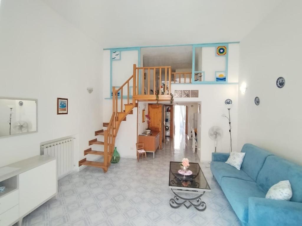 a living room with a blue couch and a staircase at Ischia Ponte romantic apartment in the historical center and near the sea in Ischia