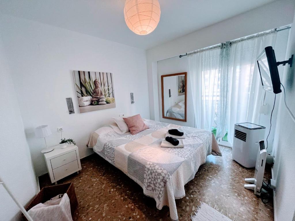 un dormitorio con una cama con un gato sentado en ella en Confort y relax centro en Valencia