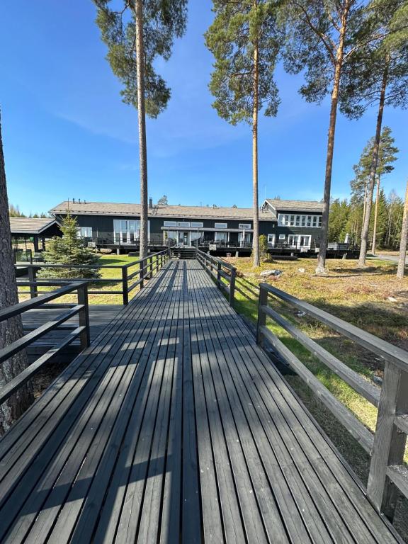 une promenade en bois avec un bâtiment en arrière-plan dans l'établissement Grand Hideout Lake Päijänne, à Vääksy