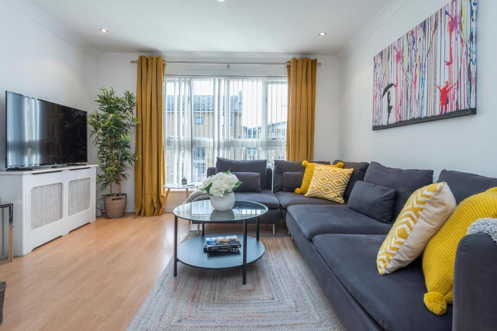 a living room with a couch and a tv at 2 Bed town house with Garden in Hackney, London in London