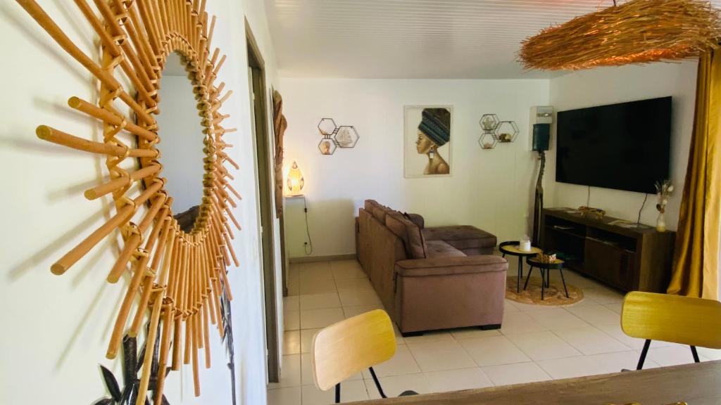 ein Wohnzimmer mit einem Sofa und einem TV in der Unterkunft MAJO BEACH in Saint-Pierre