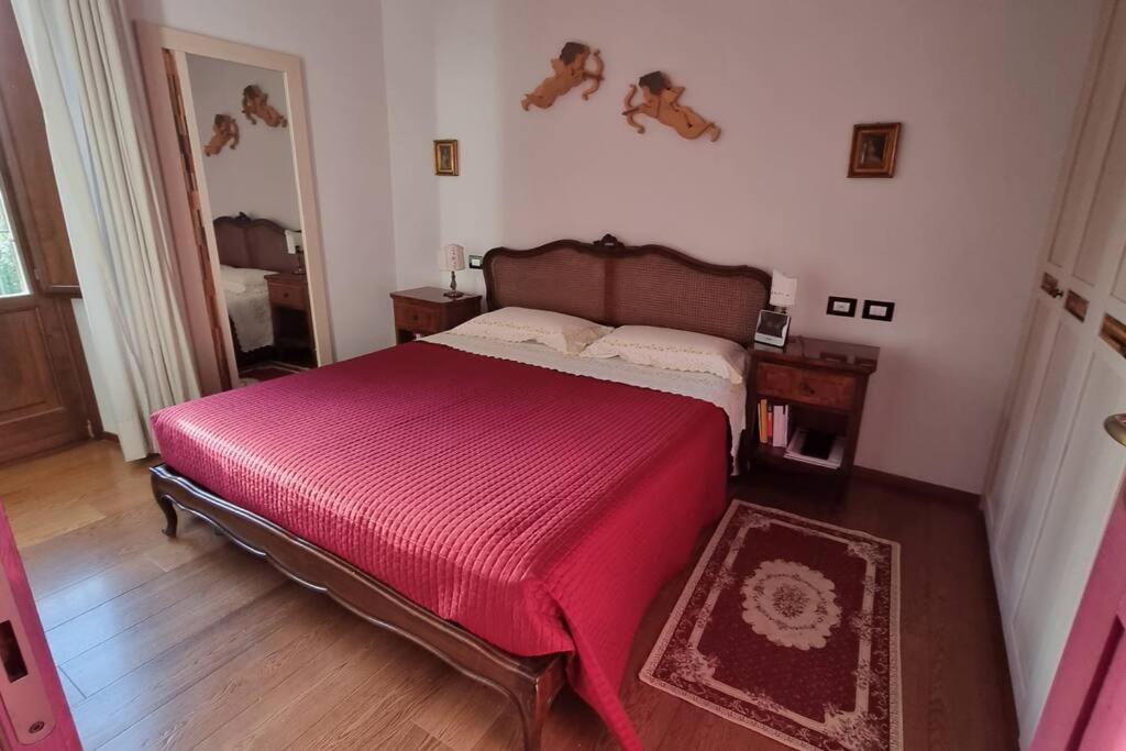 una camera da letto con un grande letto con una coperta rossa di Stanza dei Mercanti a Orvieto