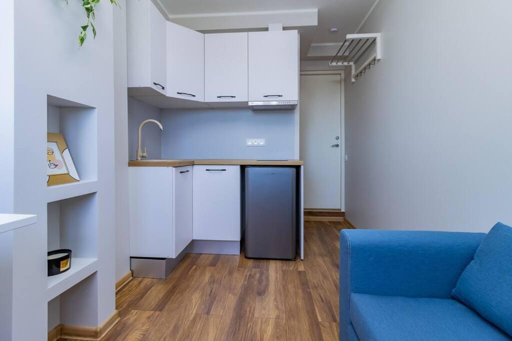 a kitchen with a blue couch in a room at Studio flat in Tallinn