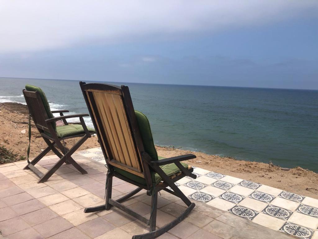 two chairs sitting on the beach near the ocean at Grotte au bord de mer in Tiznit