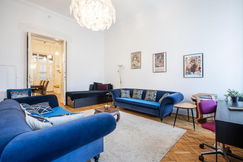 ein Wohnzimmer mit blauen Möbeln und einem Kronleuchter in der Unterkunft Court Crossing Apartment in Budapest