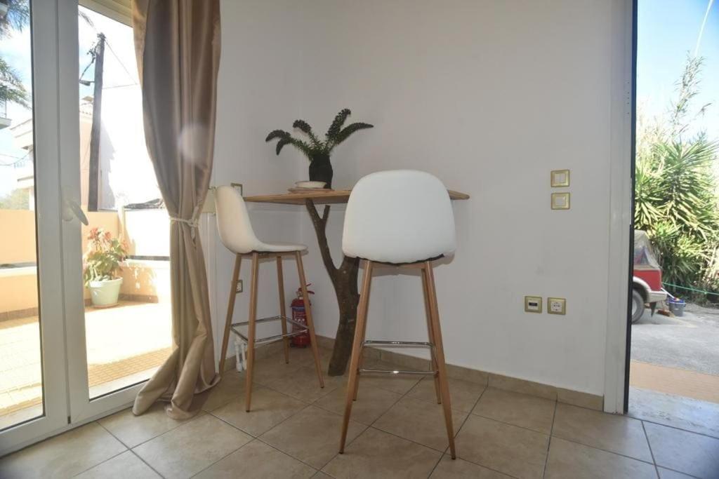une table avec deux chaises blanches et une table avec une plante dans l'établissement Anna's Central Hideaway, à Ágios Rókkos