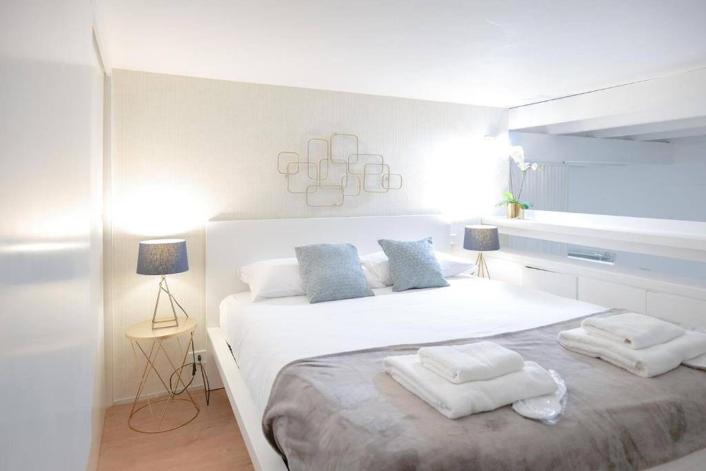 een slaapkamer met een groot wit bed en handdoeken bij Loft 5c - Palatino in Rome