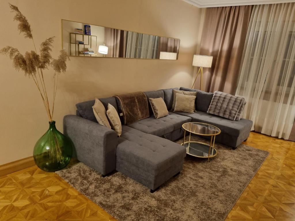ein Wohnzimmer mit einem blauen Sofa und einem Tisch in der Unterkunft Villa with private Sauna and Jacuzzi, 8 min from Schloss Schöbrunn in Wien