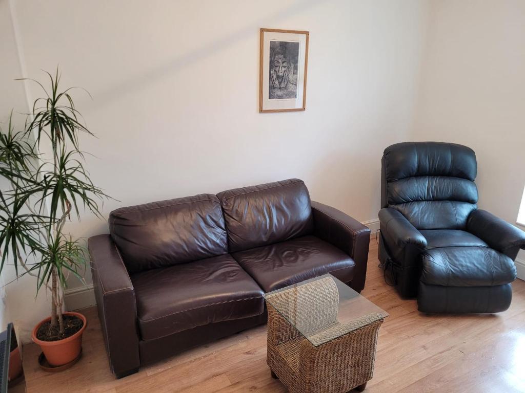 - un canapé en cuir et une chaise dans le salon dans l'établissement Heart of City DE1 One Bedroom Apartment, à Derby