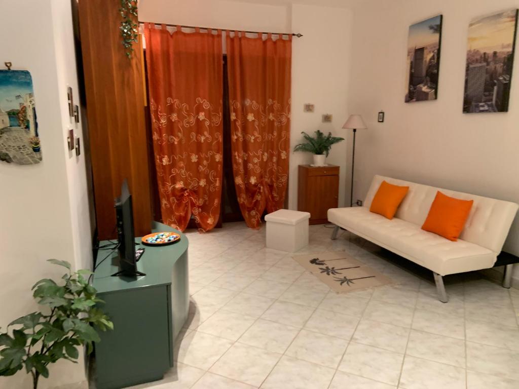 uma sala de estar com um sofá e uma televisão em Holiday Home 40 em Santa Maria delle Mole