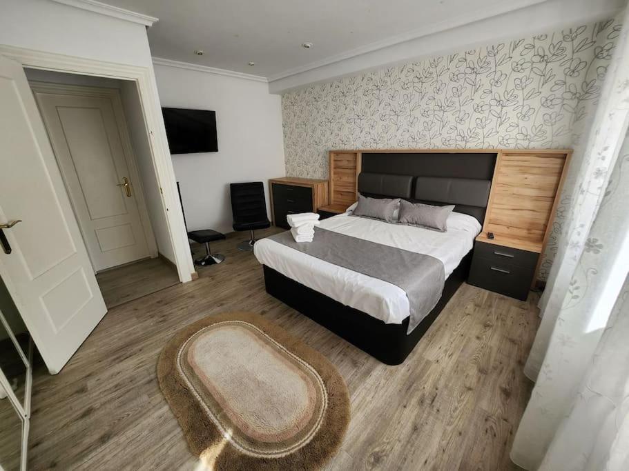 - une chambre avec un grand lit et un tapis dans l'établissement Céntrico y elegante apartamento en Castellón, Castellón de la Plana