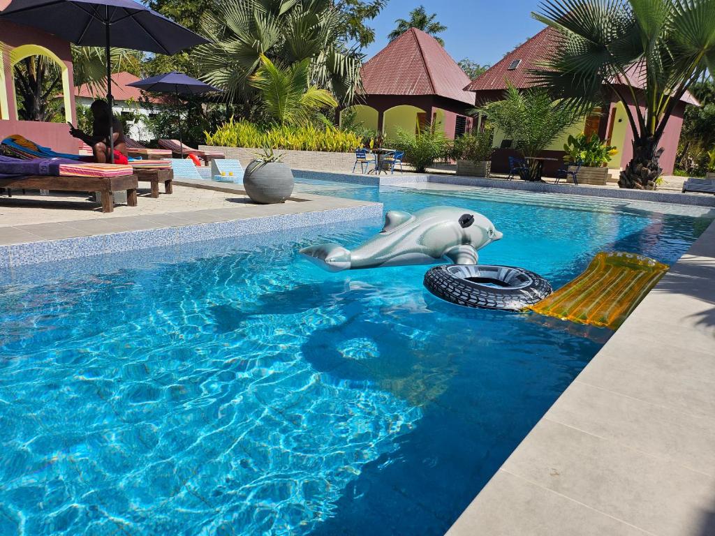 a pool with a hippo swimming in the water at Asamai Villas 