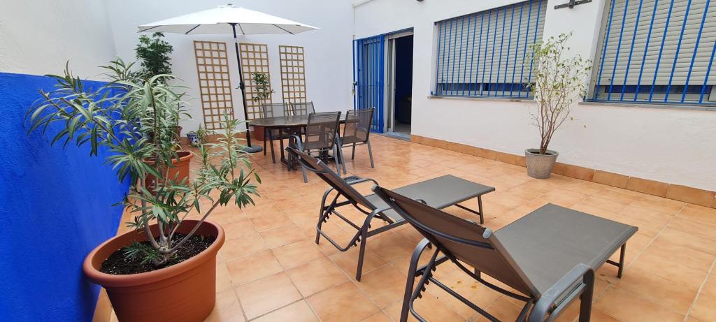 a patio with tables and chairs and potted plants at Apto T Patio Sevillano - Garaje privado in Seville