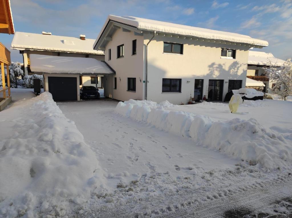 a driveway covered in snow in front of a house at Ferienwohnung Morgensonne in Bad Feilnbach