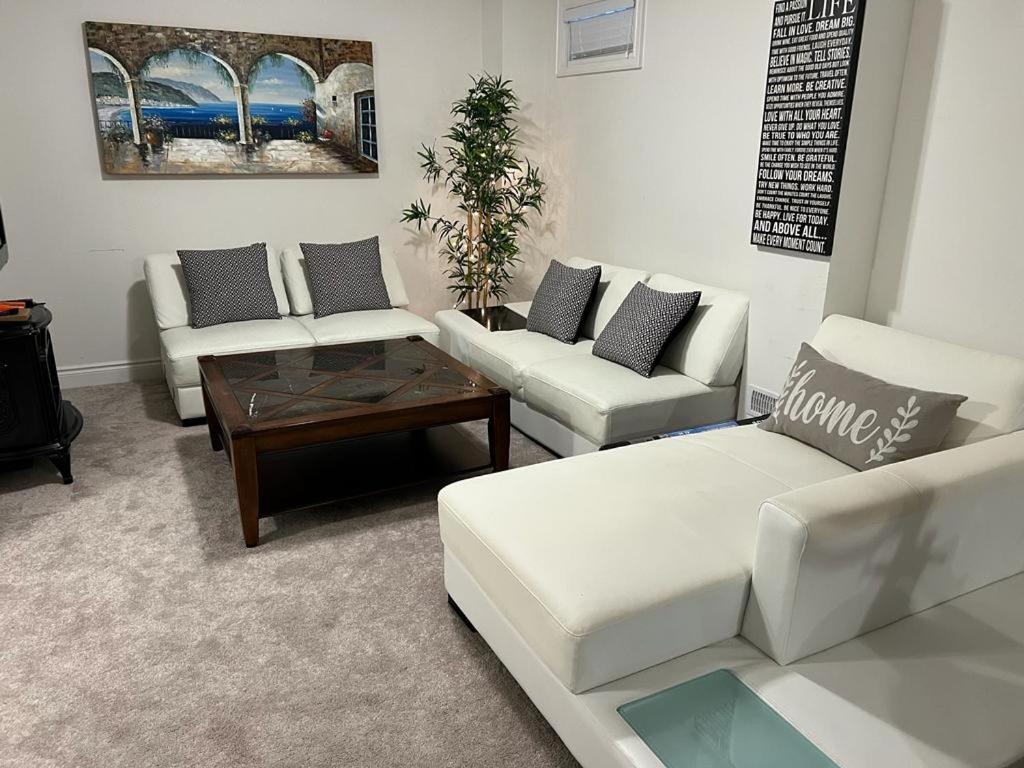 a living room with white couches and a coffee table at Cozy, Spacious 2 bdrm basement apartment with kitchenette, sleeps up to 5 in Brampton