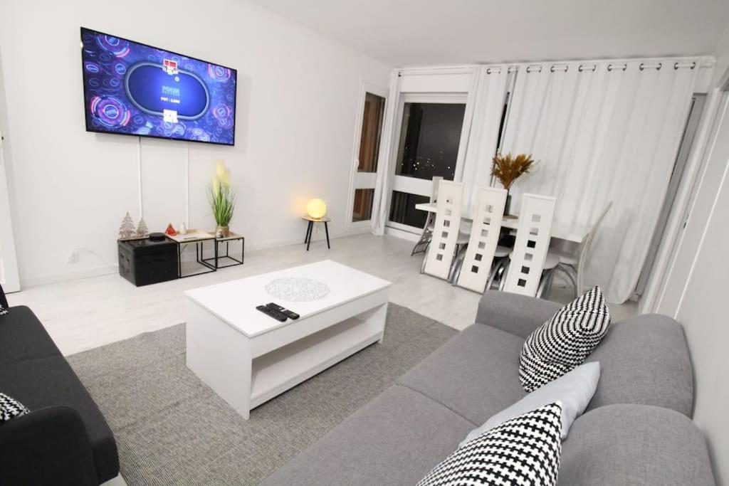 a living room with a couch and a tv at Bel appartement meublé 4 pièces in Ris-Orangis