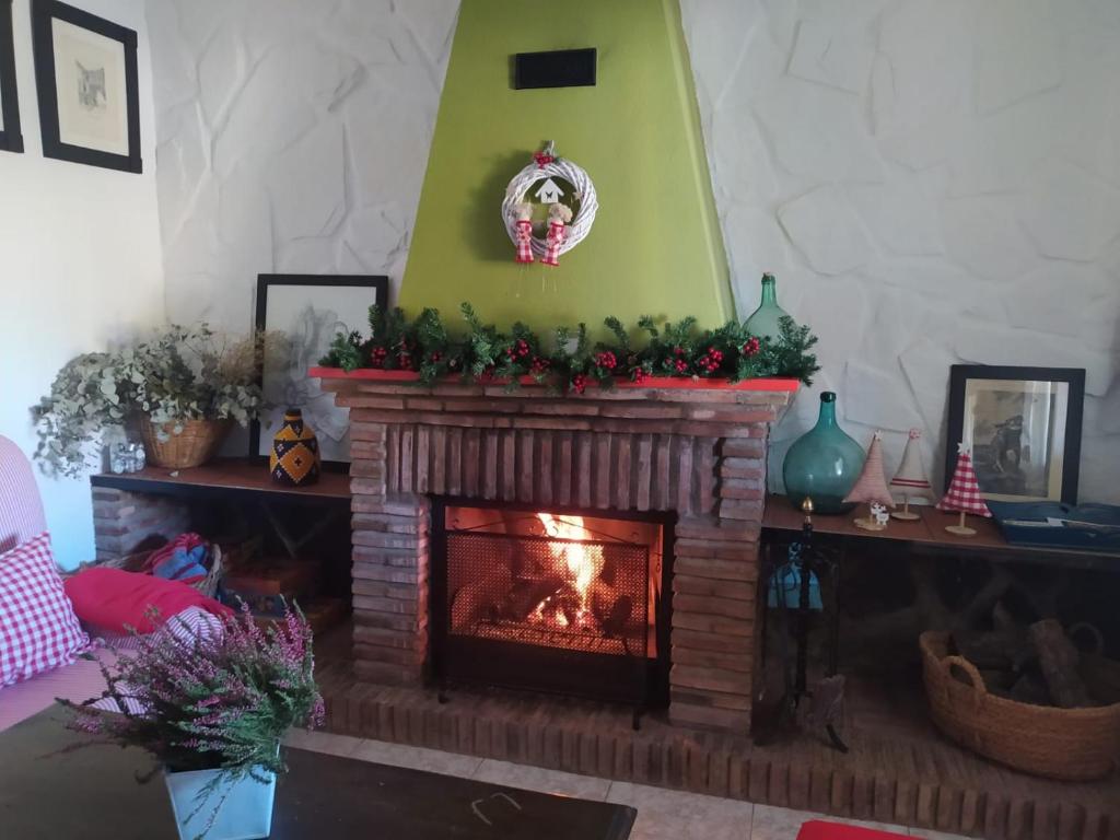 a living room with a fireplace with christmas decorations at Casa Rural Tazgona in Antequera