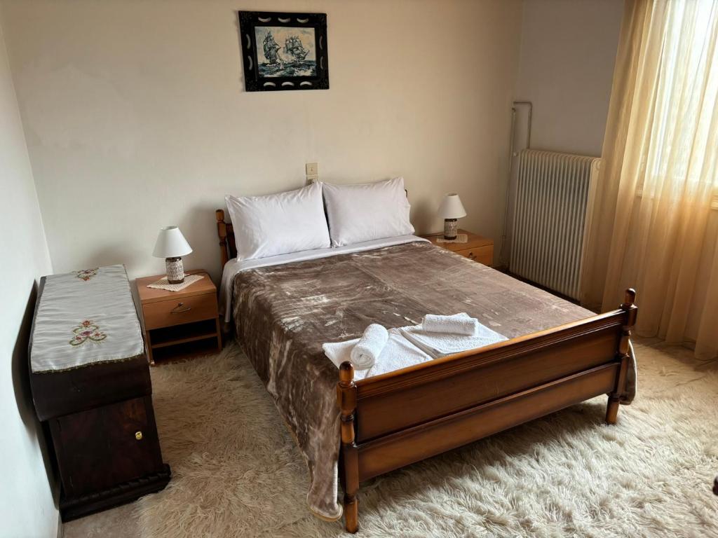 - une chambre avec un grand lit et 2 tables de chevet dans l'établissement Georgaras Accommodation, à Platanoússa