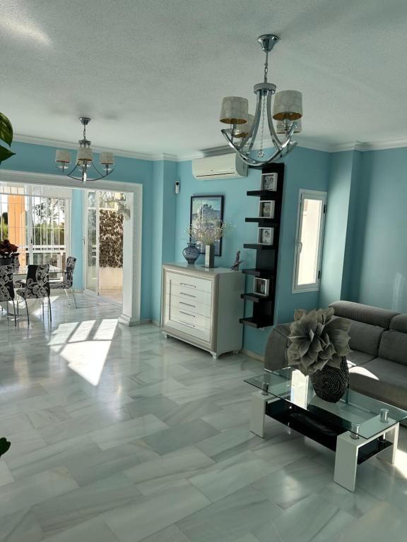 sala de estar con paredes azules y sofá en Casa Caracol, en La Herradura