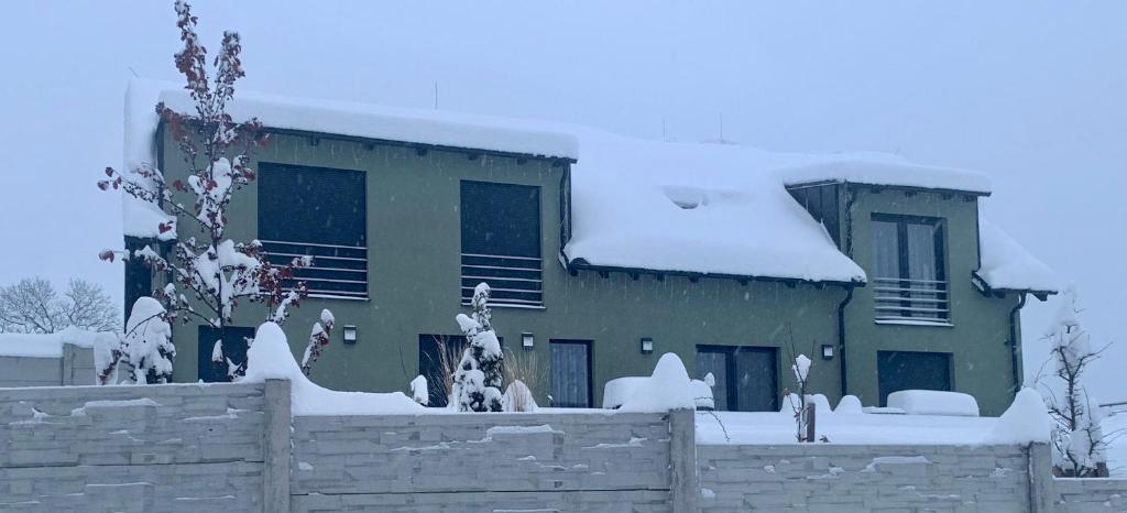 a house covered in snow with a fence at CHALET HOUBOVÝ VRCH in Horní Planá