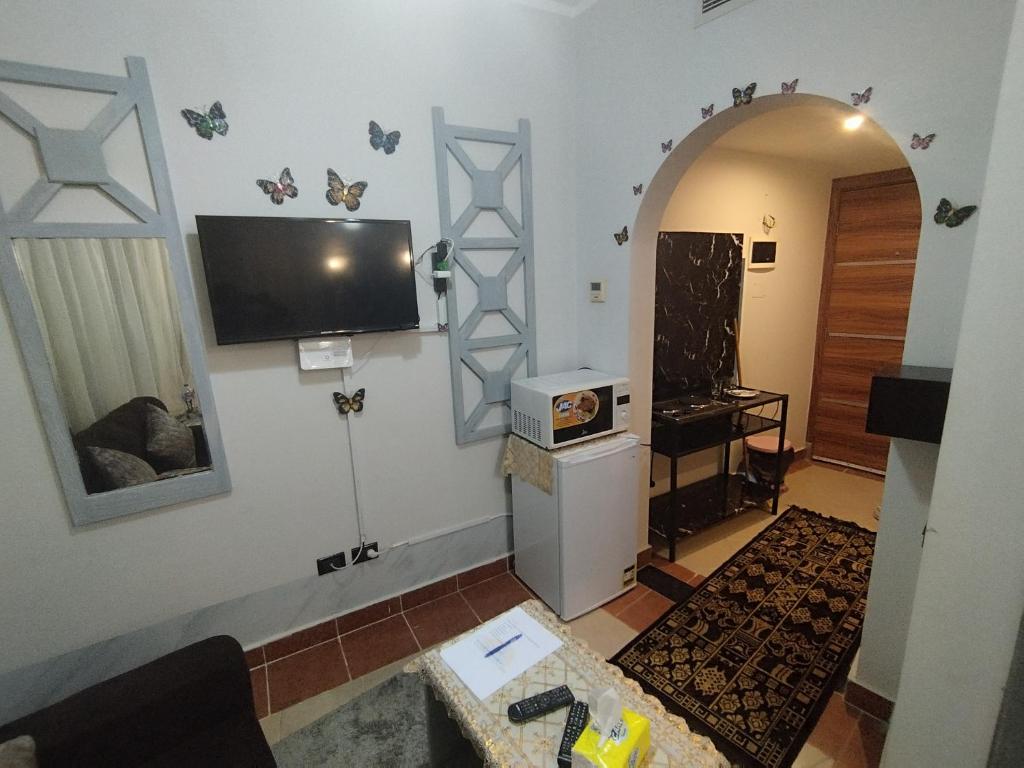 a living room with a tv on the wall at royal beach resort hurghada in Hurghada