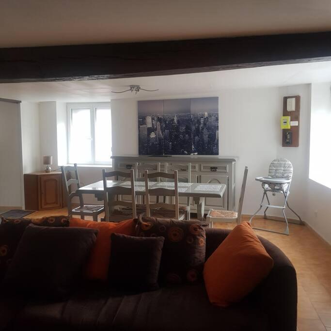 un salon avec un canapé, une table et des chaises dans l'établissement Chez Nino wifi gratuit, à Beaulieu-sur-Loire