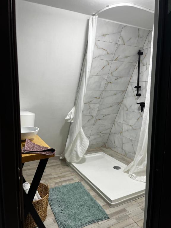 a shower in a room with a shower curtain at Rock Valley Cabins in Ibăneşti