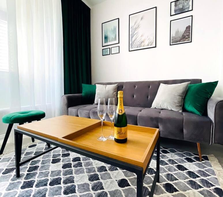 a living room with a bottle of champagne and two wine glasses at Apartmán Twins Green blízko centra in Michalovce
