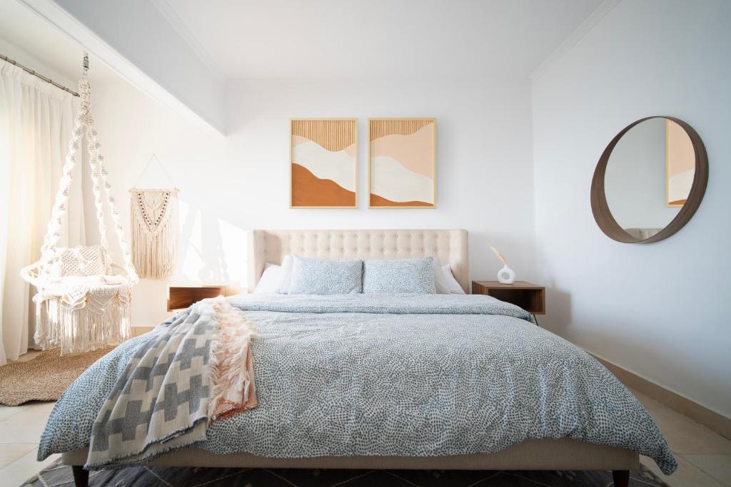 アレクサンドリアにあるNabeel Homes - Seaview Condo - SP11の白いベッドルーム(ベッド1台、鏡付)