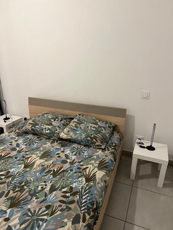 um quarto com uma cama com um cobertor e uma mesa em Résidence neuve le K 10 mn gare, parking , tram em Montpellier
