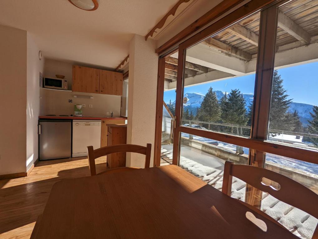 a kitchen with a table and a large window at Appartement Chamrousse, 4 personnes - Village du Bachat in Chamrousse