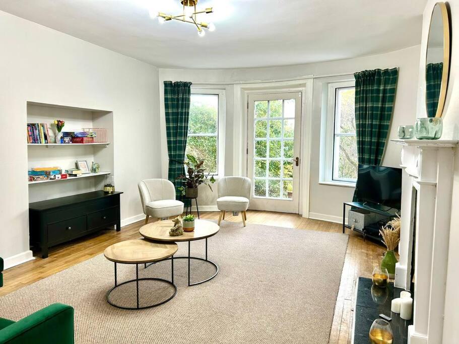 uma sala de estar com um sofá, uma mesa e cadeiras em Foyleview Villa em Derry Londonderry