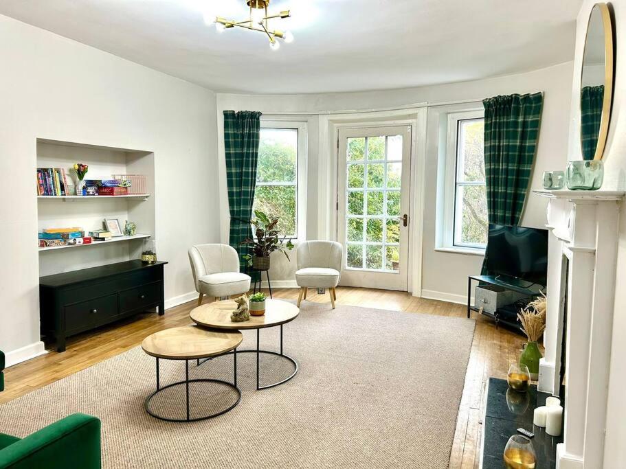 Una sala de estar con un sofá, una mesa y sillas. en Foyleview Villa, en Derry Londonderry