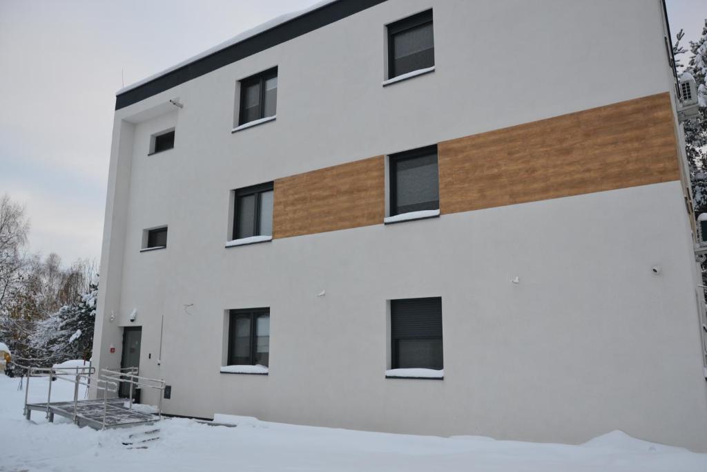 un edificio blanco con nieve delante en VILLA HALINTON en Wodzisław Śląski