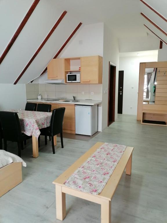 ein Wohnzimmer mit einem Tisch und einer Küche in der Unterkunft Gondola 22 in Kopaonik