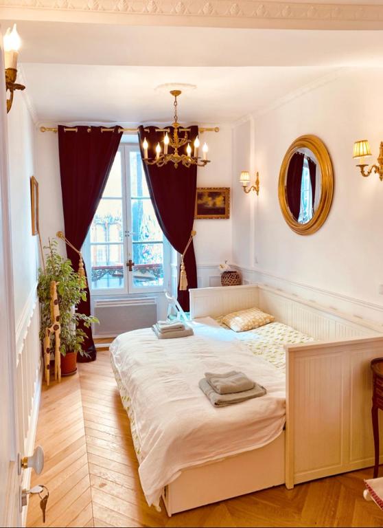 - une chambre avec un grand lit et un lustre dans l'établissement Parisian style Appartment Private room with Shared bathroom near Bastille and Gare de Lyon, à Paris