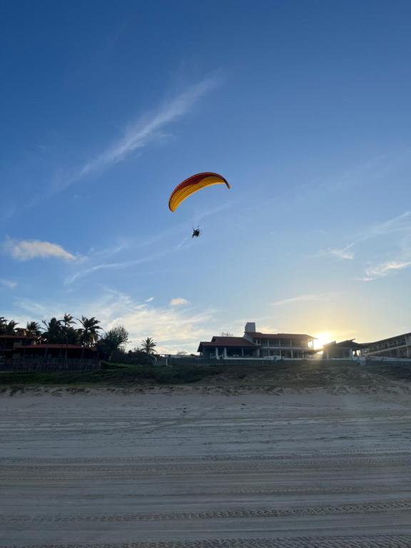 una persona sta volando un aquilone sulla spiaggia di Apto 2 quartos - Condomínio Frente Mar a Beberibe