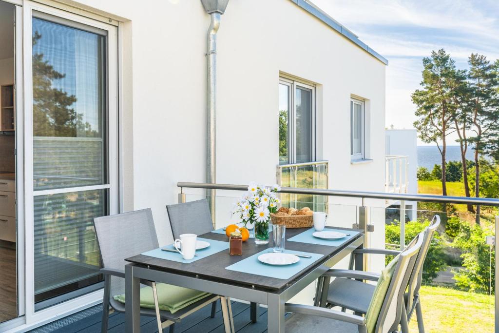 a table and chairs on the balcony of a house at Apartment "Inselglück" - Haffresidenz in Garz