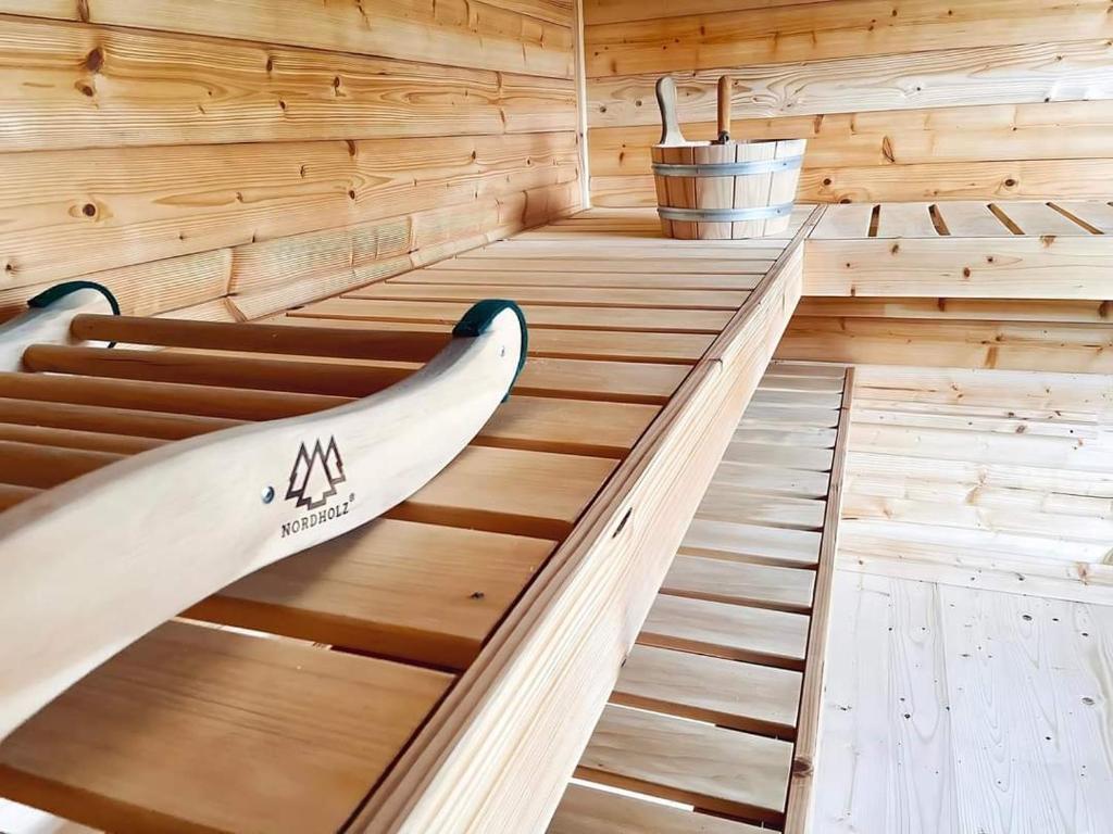 a wooden sauna with a surfboard sitting in it at Lessük meg! Vendégház - Sümeg in Sümeg