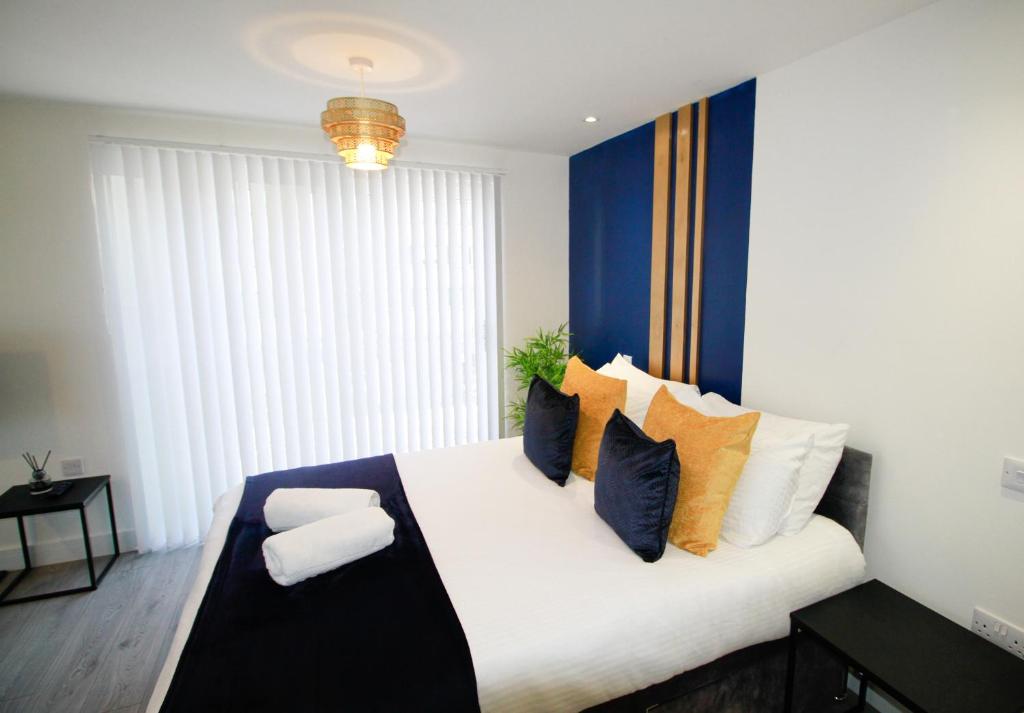 1 dormitorio con 1 cama grande y almohadas coloridas en Modern Studio for LONG STAY BUSINESS & RELOCATIONS en Hemel Hempstead