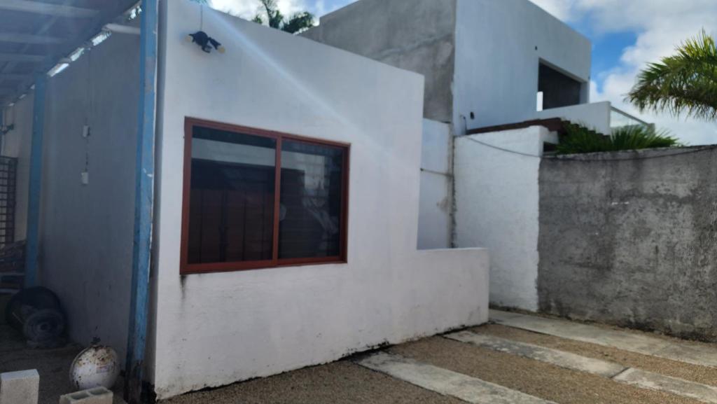 ein weißes Gebäude mit einem Seitenfenster in der Unterkunft Casa en Mahahual cerca de la playa in Mahahual