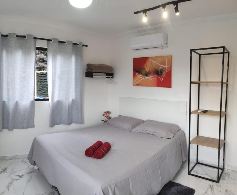ein Schlafzimmer mit einem Bett mit roten Kissen darauf in der Unterkunft Casa Nova no Centro de Penedo in Penedo