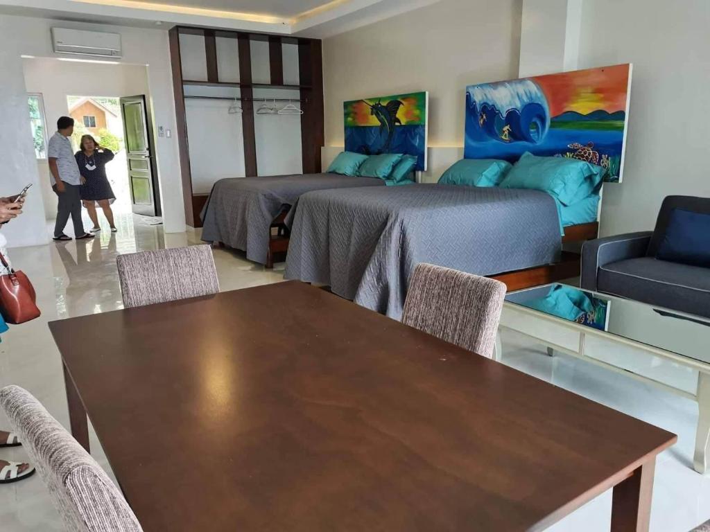 サマルにあるAundanao Oasis Beachのベッド2台、テーブル、椅子が備わる客室です。