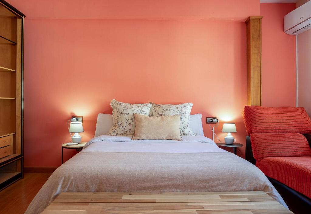 1 dormitorio con cama y pared roja en APARTAMENTO TURÍSTICO ABUELO TEÓFILO, en Tornavacas